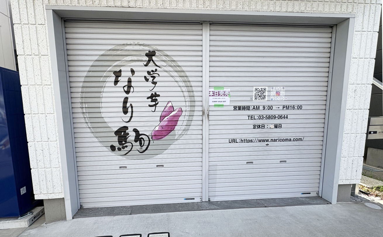 シャッターに大きくプリントされた「なり駒」の筆文字ロゴ