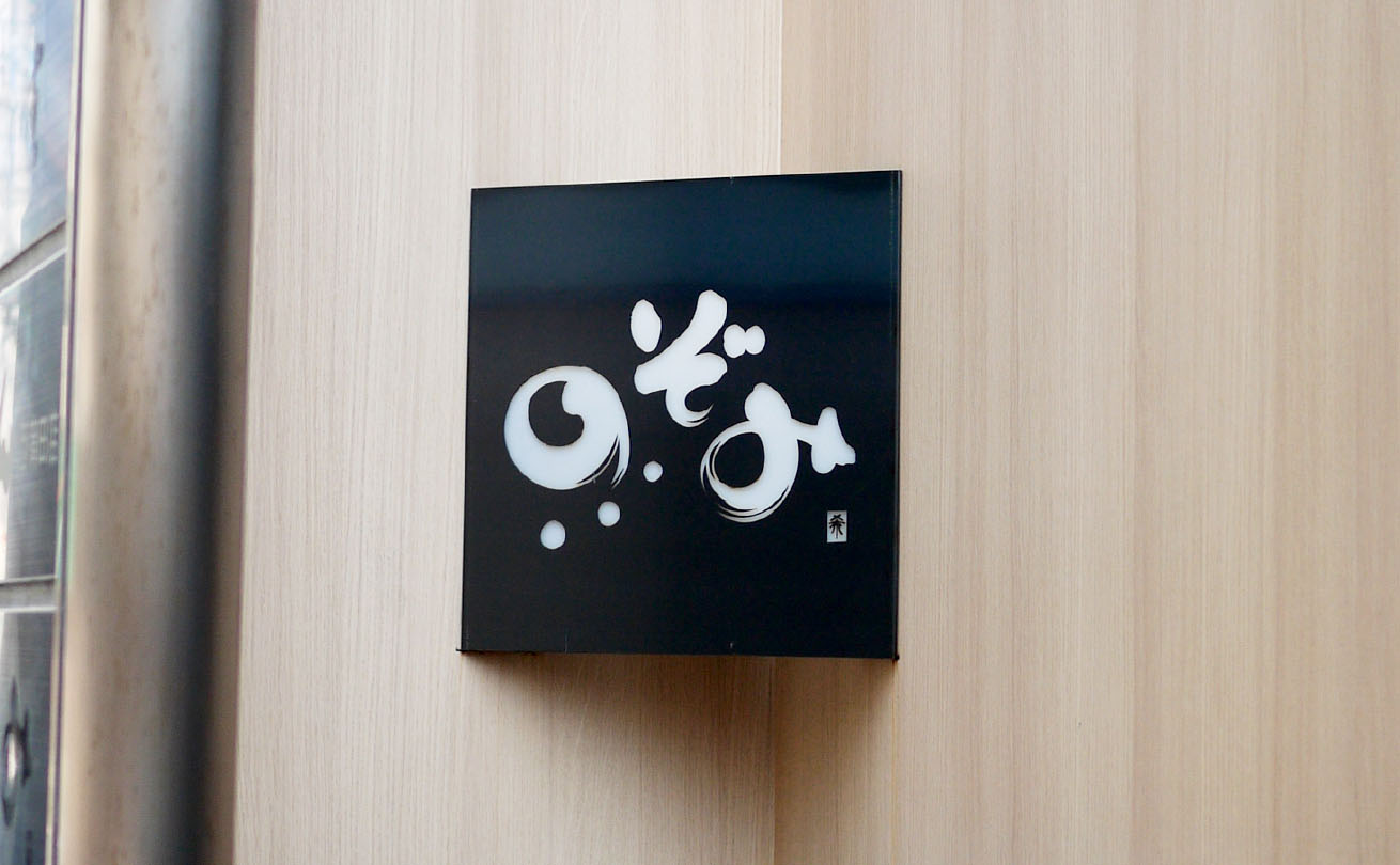 地下店舗へ続く階段上に設置された隠れDining のぞみの看板