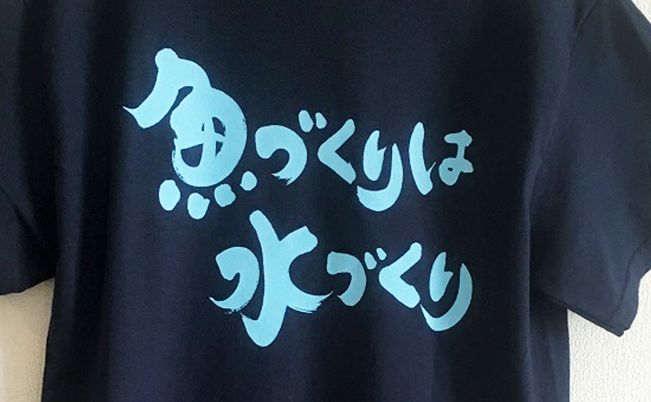 「魚づくりは水づくり」の筆文字を背面にプリントした販促用Tシャツ