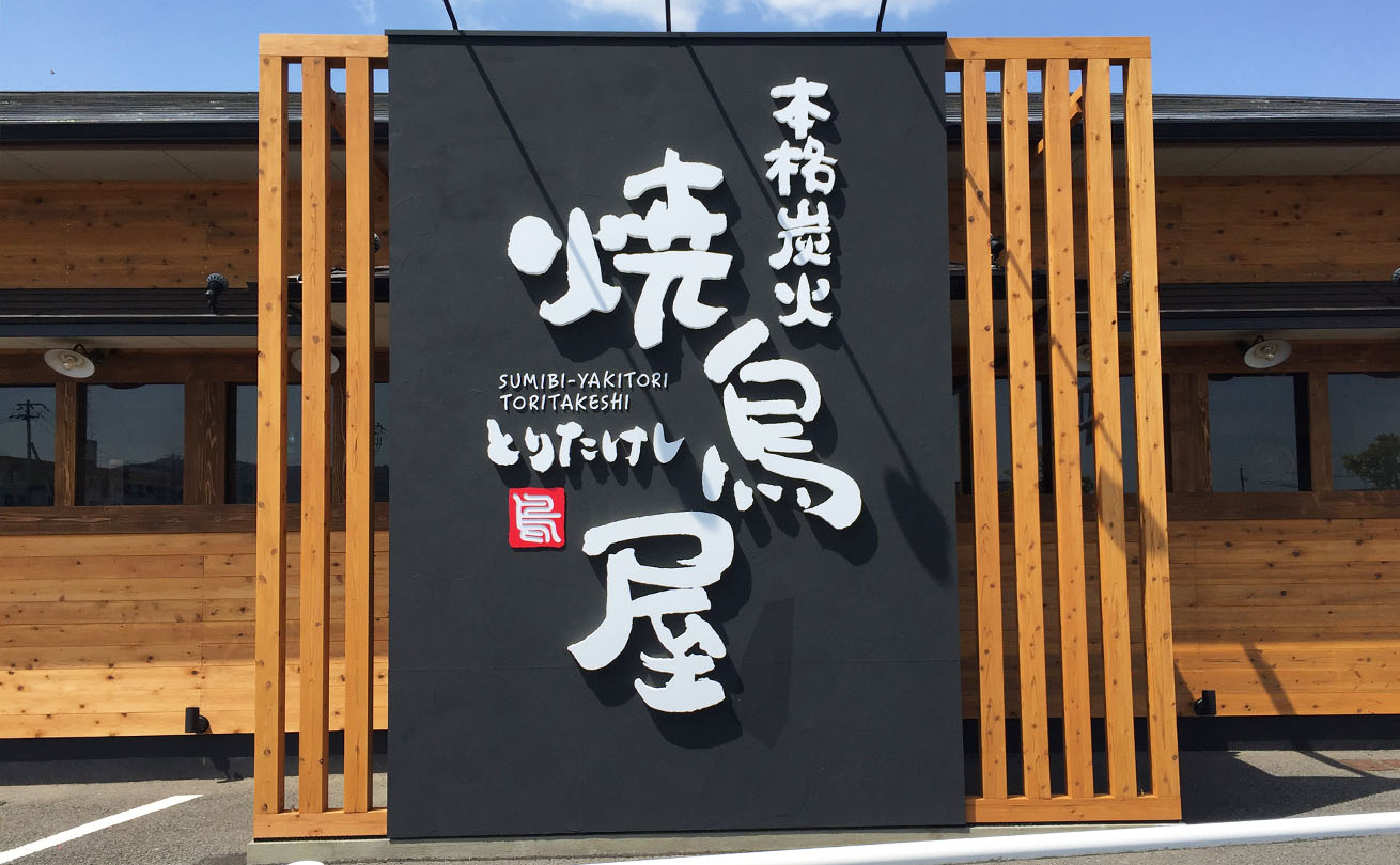 丸みのある親しみやすい筆文字ロゴ「本格炭火 焼鳥屋 とりたけし」の店舗看板