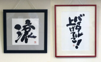 社内の壁に額装された筆文字作品『滾』と『バイタル上げてこ！』