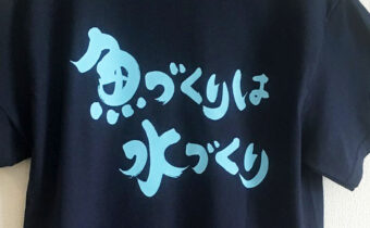 筆文字で書いた『魚づくりは水づくり』がプリントされたTシャツ