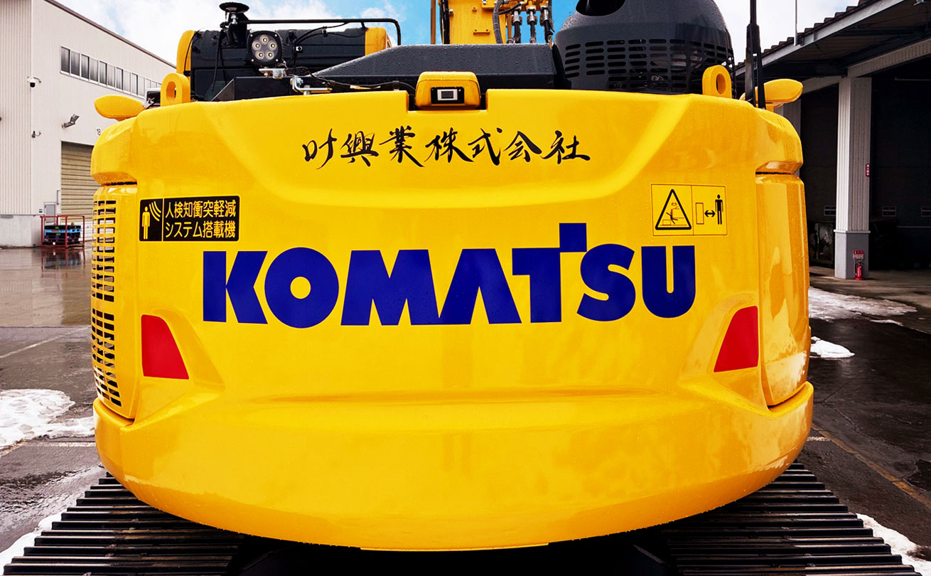 叶興業株式会社とカッティングシートで筆文字をかたどったロゴが入っているユンボの背面